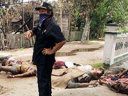 Un funcionario gubernamental, junto a cadáveres de varios inmigrantes madureses, algunos de ellos decapitados, ayer en Sampit, en la isla de Borneo.