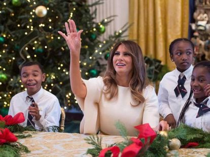 Melania Trump, la primera dama de los Estados Unidos, arroja un adorno navideño mientras hace guirnaldas con niños en la Casa Blanca.