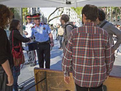 Miembros del 'multirreferèndum' desmontan una de las mesas obligados por los Mossos d'Esquadra.