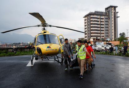 Personal de emergencia transporta el cuerpo de uno de los fallecidos en el accidente de helicóptero en el Himalaya. 