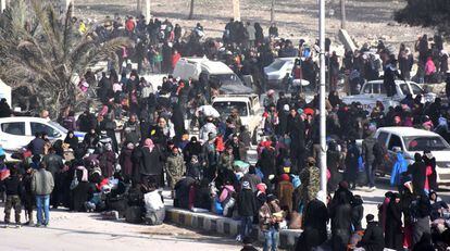 Centenars de sirians esperen en un control del Govern, després d'abandonar la zona est rebel de la ciutat d'Alep.