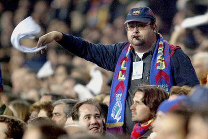 Un aficionado sigue un partido desde las gradas del Camp Nou con un puro en la boca.