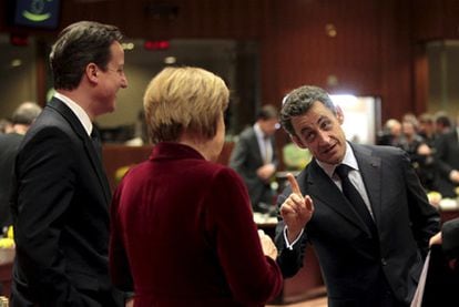 El primer ministro británico, David Cameron (a la izquierda), y la canciller alemana, Angela Merkel, escuchan al presidente francés, Nicolas Sarkozy, en un receso del Consejo Europeo.