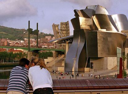 Una pareje en el paseo Abandoibarra, frente al museo Guggenheim y la Ría de Bilbao