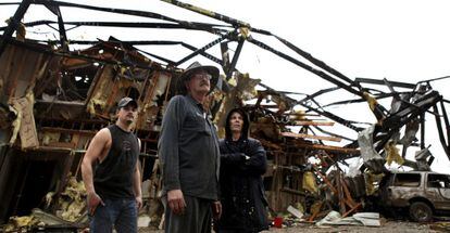 Los dueños de un negocio en el sur de Indiana, tras el paso de un tornado.