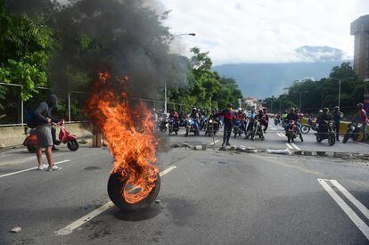 Uno grupo de manifestantes bloquea una avenida de Caracas.