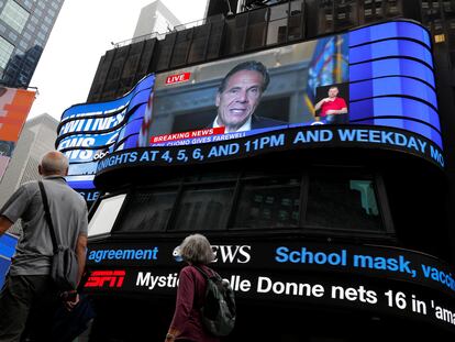 La gente pasa caminando mientras el gobernador de Nueva York, Andrew Cuomo, transmite en vivo su discurso de despedida en una pantalla en Times Square, Nueva York, el 23 de agosto de 2021.