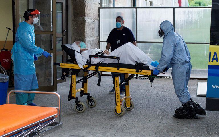 Trabajadores sanitarios trasladan este domingo a enfermos por coronavirus al Hospital de Piñor, en Ourense.