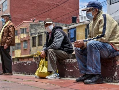Hombres esperan a recibir alimentos afuera de un comedor comunitario en Bogotá, en 2020.