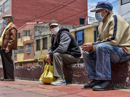 Hombres esperan a recibir alimentos afuera de un comedor comunitario en Bogotá, en 2020.