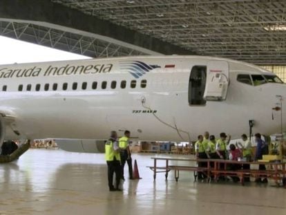 Los técnicos inspeccionan un Boeing 737 MAX 8 en un hangar del aeropuerto de Soekarno Hatta, en Yakarta (Indonesia). En vídeo, declaraciones de pasajeros de uno de estos aviones tras su paralización en EE UU este miércoles.