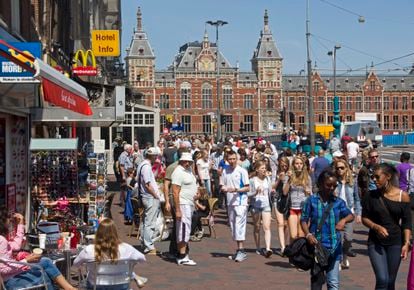 Visitantes en la avenida Damrak, cerca de la Estación Central de Ámsterdam.