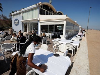 Una camarera prepara una mesa en la terraza en uno de los restaurantes de la playa de la Malvarrosa de Valencia, el pasado lunes.