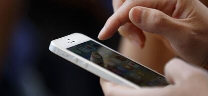 Una persona, utilizando un teléfono móvil iPhone.