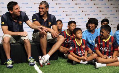 Messi, junto a Pinto, bromea con un niño con el pantalón del Madrid