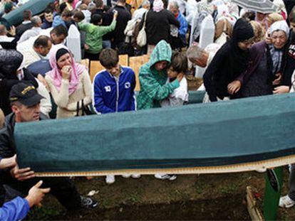 Familiares llevan el cadaver de una víctima de la masacre al lugar del entierro.