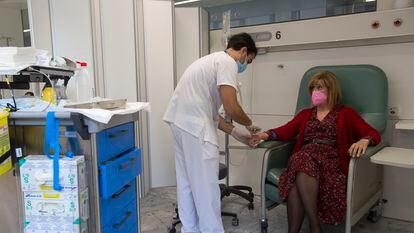 Un enfermero prepara una dosis de quimioterapia para una paciente con cáncer.