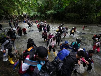 Migrantes cruzan un río en la selva del Darién para llegar a Panamá, el 15 de octubre de 2022.