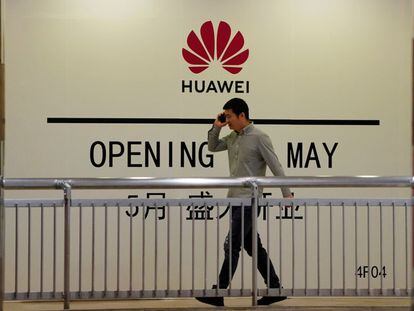 Un hombre camina frente a una tienda de Huawei que aun no ha sido inaugurada en Shanghái.
