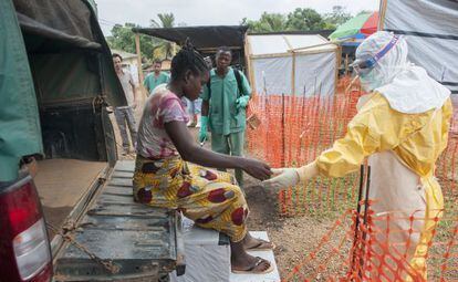 Miembros de M&eacute;dicos Sin Fronteras ayudan a una enferma de &eacute;bola en Guinea. 
