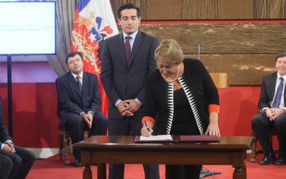 Bachelet firma un decreto ante la mirada de Pe&ntilde;ailillo.
