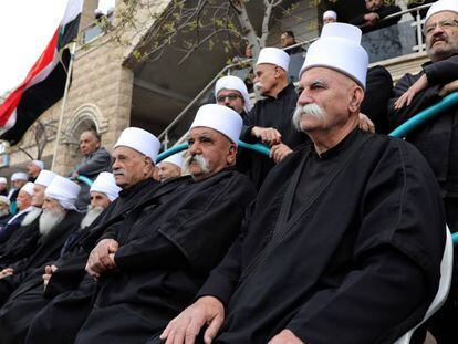 Líderes religiosos drusos con la bandera siria, en una protesta el sábado en Majdal Shams. En vídeo, Trump reconoce los Altos del Golán como territorio israelí.