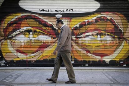 Un home passeja davant d'un grafiti a Grècia que pregunta: "Què vindrà després?".