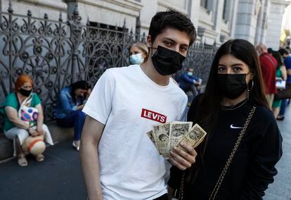 Mario Rodríguez, de 18 años, junto a su hermana Alba, de 23, esperan para cambiar las pesetas de su abuela en el banco de España.