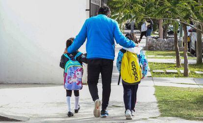 Un hombre camina con dos de sus hijas, afuera del colegio en Coahuila, al norte de México.