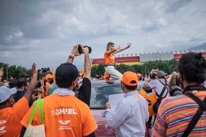 Mariana Rodríguez pega propaganda de su esposo en los techos de los autos que asistieron al cierre de campaña en Monterrey.