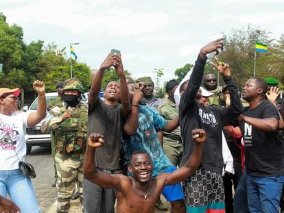 Varias personas posan con soldados al origen del golpe de Estado, en una calle de Libreville, Gabón el pasado 20 de agosto.