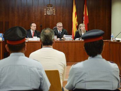 El acusado escoltado por los dos mossos en la sala de vistas