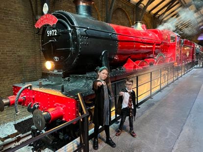Los hijos de Adrián Rodríguez y Gosi Bendrat, autores del blog 'Mola Viajar', junto a la locomotora del Hogwart Express en los estudios de rodaje de las películas de Harry Potter.