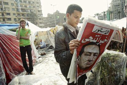 Un hombre lee en la plaza de la Liberación un periódico que anuncia la renuncia de Mubarak.