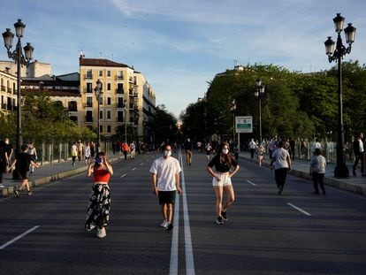 Varias personas caminan el pasado domingo por la calzada para mantener la distancia en el viaducto de Segovia, en Madrid.