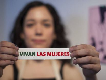 Una colaboradora de 'Vivan las mujeres' sujeta una pegatina contra la violencia machista.