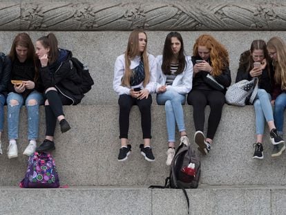 Varias adolescentes usan sus teléfonos móviles en la Plaza Trafalgar de Londres, en mayo de 2019.