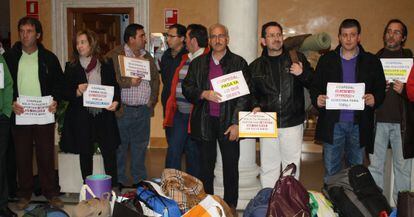 Los alcaldes que se han encerrado en una delegación de la Junta, con carteles de protesta.