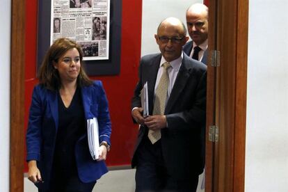 La vicepresidenta del Gobierno, Soraya Sáenz de Santamaría, junto al ministro de Hacienda, Cristóbal Montoro (c), y el ministro de Economía, Luis de Guindos (d), a la llegada a la rueda de prensa que han ofrecido tras la reunión del Consejo de Ministros en la que se ha aprobado hoy los presupuestos generales del Estado para 2014, que mantendrán congeladas las retribuciones en el sector público y se apoyarán en un crecimiento económico previsto para el próximo año del 0,7 %