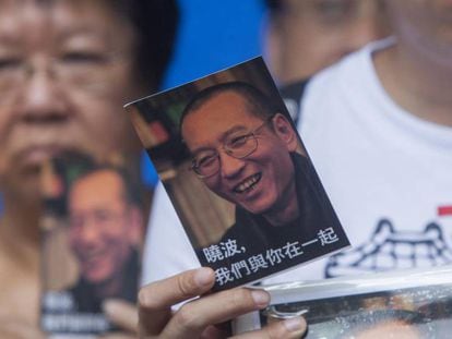 Un activista de la Alianza de Hong Kong de Apoyo a los Movimientos Democr&aacute;ticos Patri&oacute;ticos de China muestra una postal en apoyo al disidente chino Liu Xiaobo.