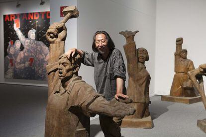 Wang Guangyi, con su obra 'Materialist, 2001-2002' y al fondo el lienzo 'Great Criticism-Art and Totem, 2007', en el MAC de A Coruña.