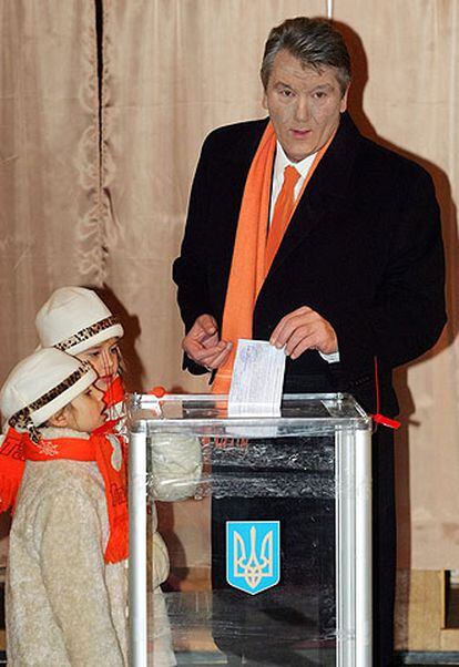 Yúshenko deposita su voto en un colegio de Kiev ante la mirada de sus hijas.