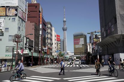 Viandantes y vehículos en un cruce de calles en Tokio.