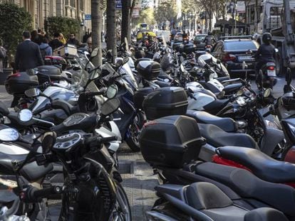 Numerosas motos aparcadas en la acera de la calle Diputació. 