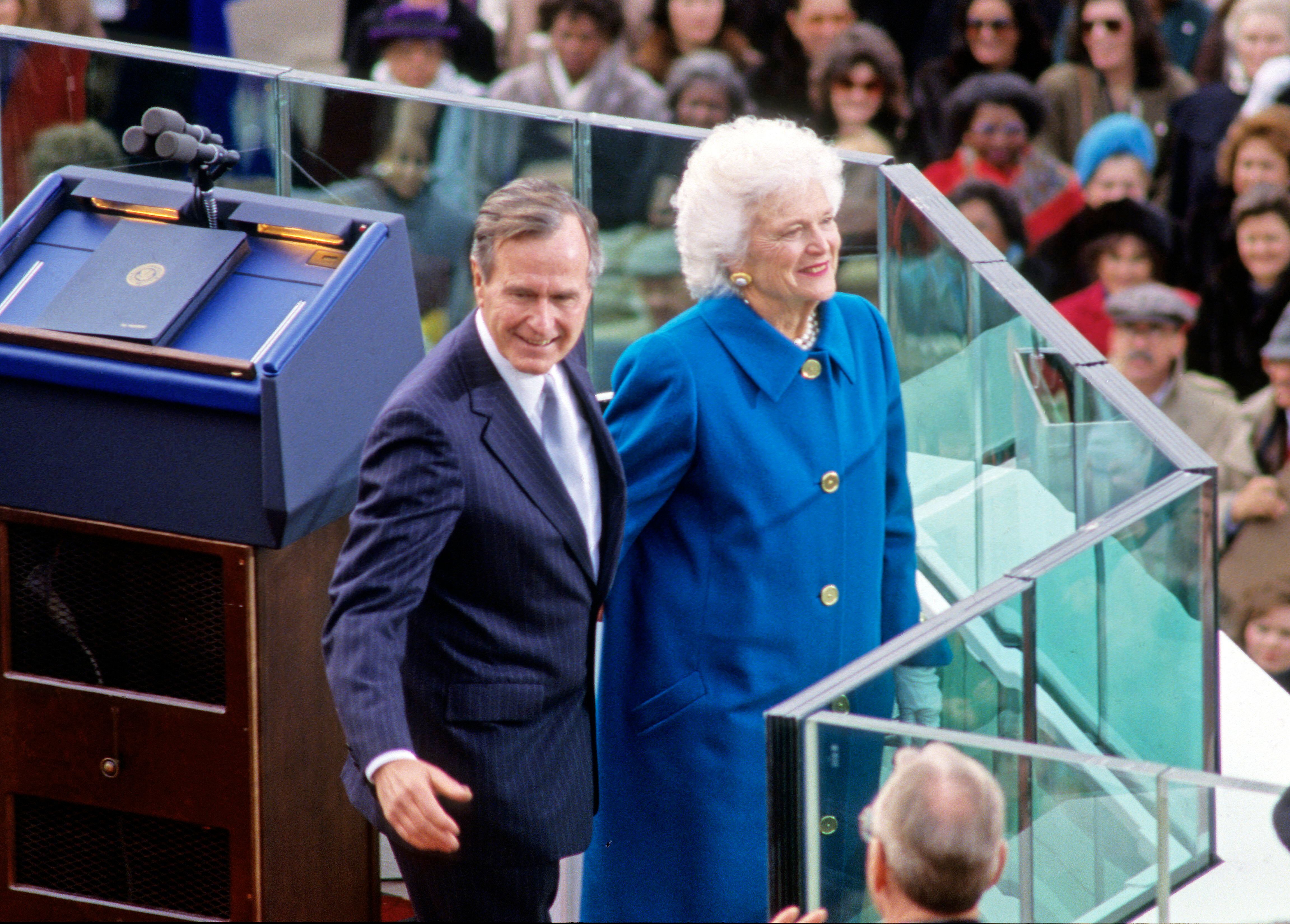 El presidente George W. H. Bush y su esposa, Barbara, sonríen ante el público en la toma de posesión del presidente en Washington el 20 de enero de 1989.