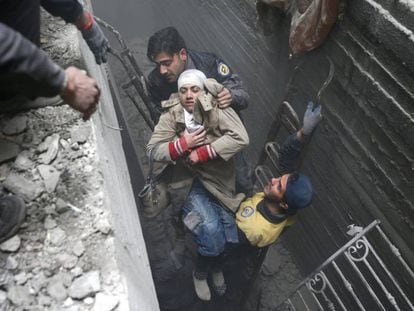 Miembros de la Defensa Civil Siria rescatan a una mujer tras un bombardeo en Duma.