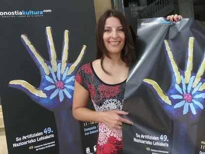 Carmen Ubago, dise&ntilde;adora gr&aacute;fica y autora de la imagen ganadora, posa con el cartel del concurso.