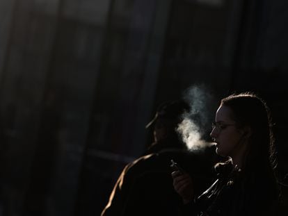 Una mujer fumaba en una calle de Cracovia, en marzo.