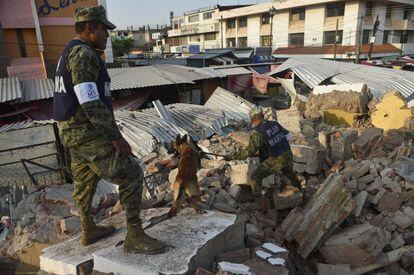 Soldados mexicanos con un perro de rescate buscan a los supervivientes en un edificio derrumbado en Juchitán de Zaragoza (México).