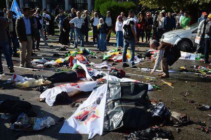 Cuerpos de las v&iacute;ctimas de los atentados yacen en la calzada cubiertos por las banderas con las que los manifestantes participaban en la marcha.
 